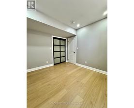 A room with wooden flooring and a door with a window.