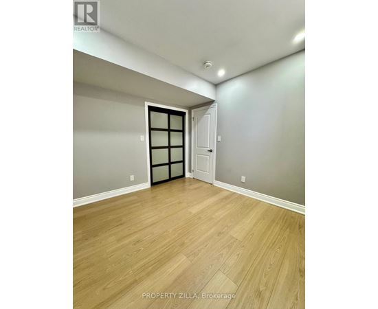 A room with wooden flooring and a door with a window.