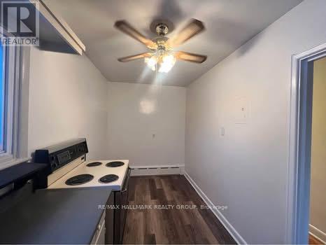 A kitchen with a stove and a ceiling fan.