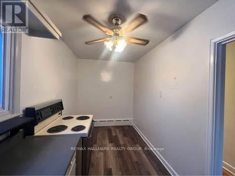 A kitchen with a stove and a ceiling fan.