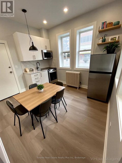 A kitchen with a table and chairs in front of a window.