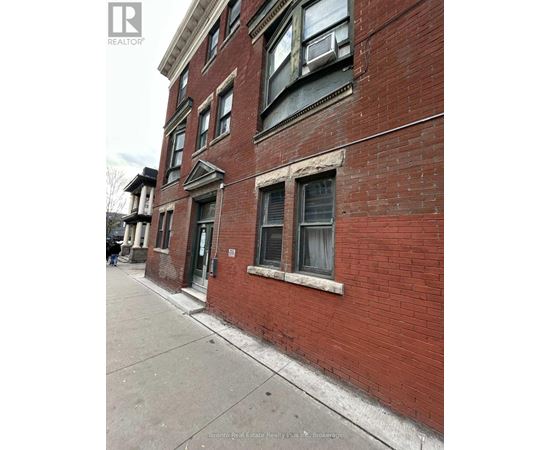 A red brick building with a window and a door.