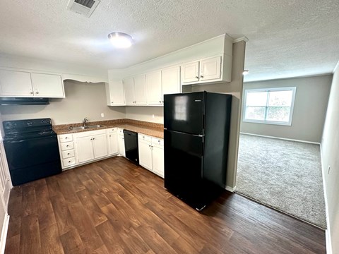 A kitchen with black appliances and white cabinets.