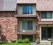 A red brick house with a balcony on the second floor.