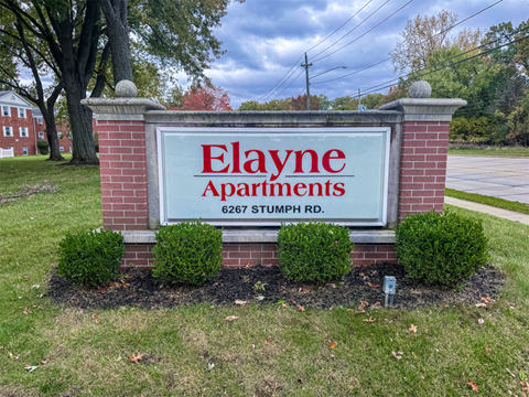 A sign for E layne Apartments is shown in front of a grassy area.