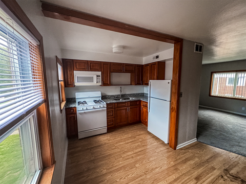 A kitchen with wooden cabinets and a white refrigerator.