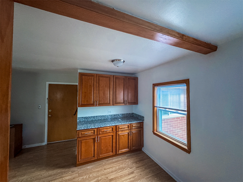 A kitchen with wooden cabinets and a window.