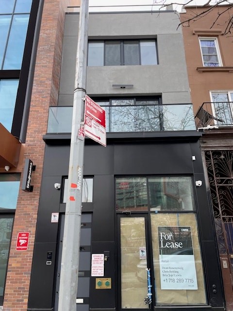 A building with a for lease sign on the front.