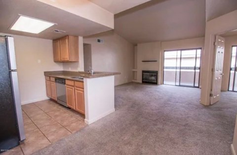 A kitchen with a refrigerator, oven, and cabinets.