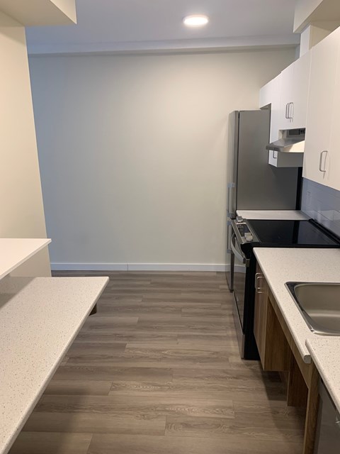 A kitchen with a sink and a refrigerator.