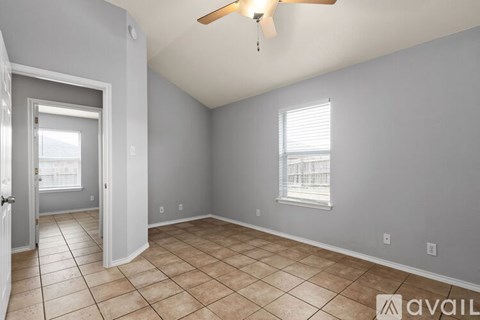 A room with a ceiling fan and a window with blinds.
