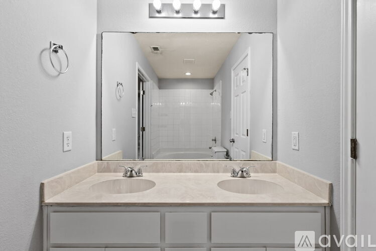 A bathroom with two sinks and a large mirror.