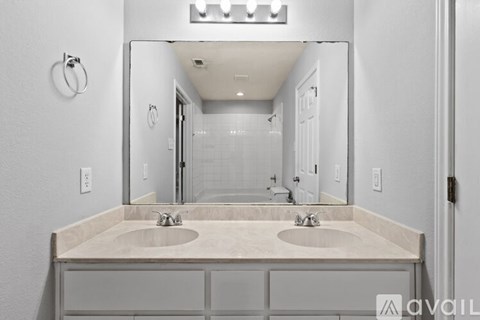 A bathroom with two sinks and a large mirror.