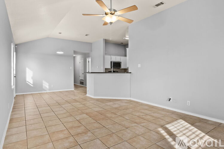A spacious room with a ceiling fan and tiled flooring.