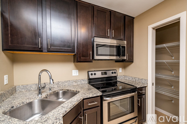 A kitchen with brown cabinets and a stainless steel sink.