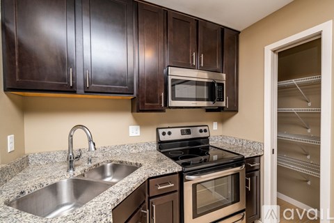 A kitchen with brown cabinets and a stainless steel sink.