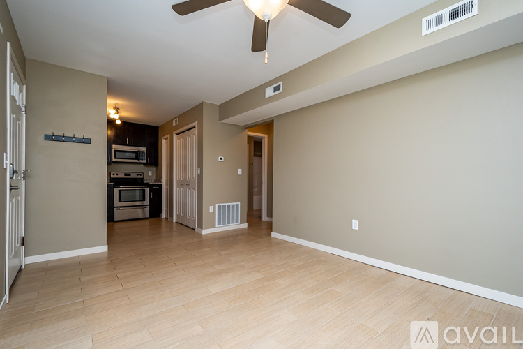 A spacious living room with a ceiling fan and hardwood flooring.
