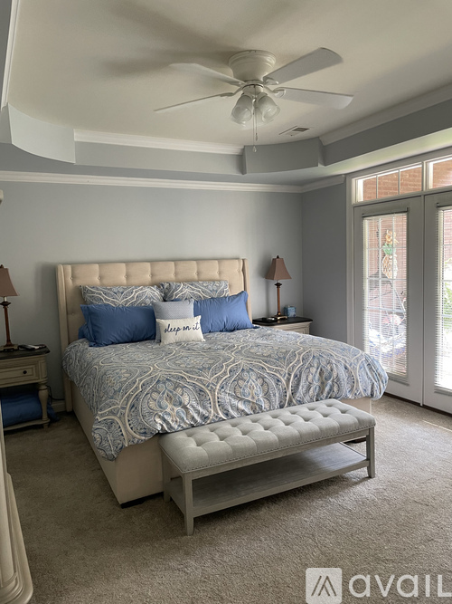 A bedroom with a large bed and a ceiling fan.