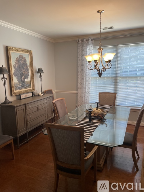 A dining room with a glass table and chairs.