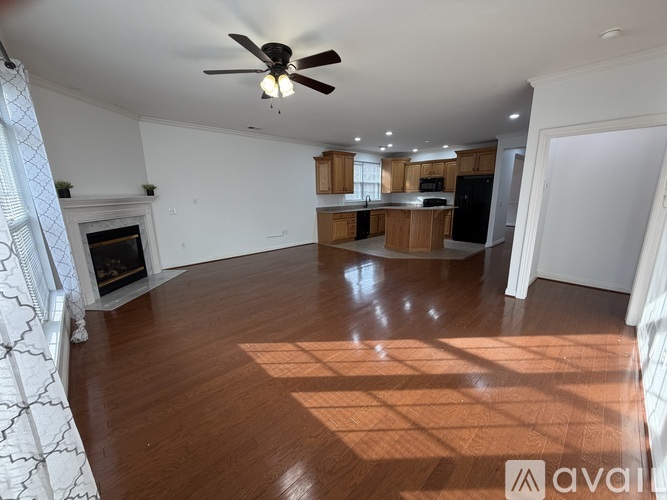 A kitchen with wooden cabinets and a black refrigerator.
