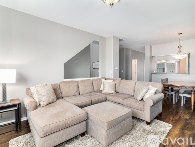 A living room with a large sectional sofa and ottoman.