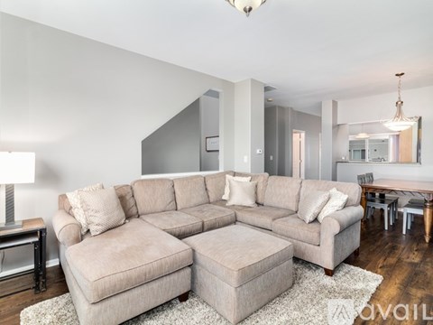 A living room with a large sectional sofa and ottoman.