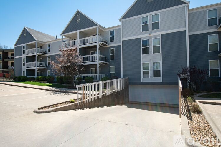 Apartment complex with a white picket fence in front.