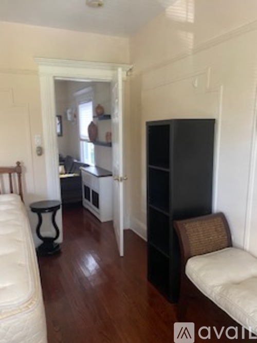 A living room with a white couch and a black bookshelf.