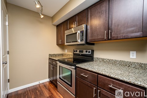 A kitchen with brown cabinets and granite countertops.