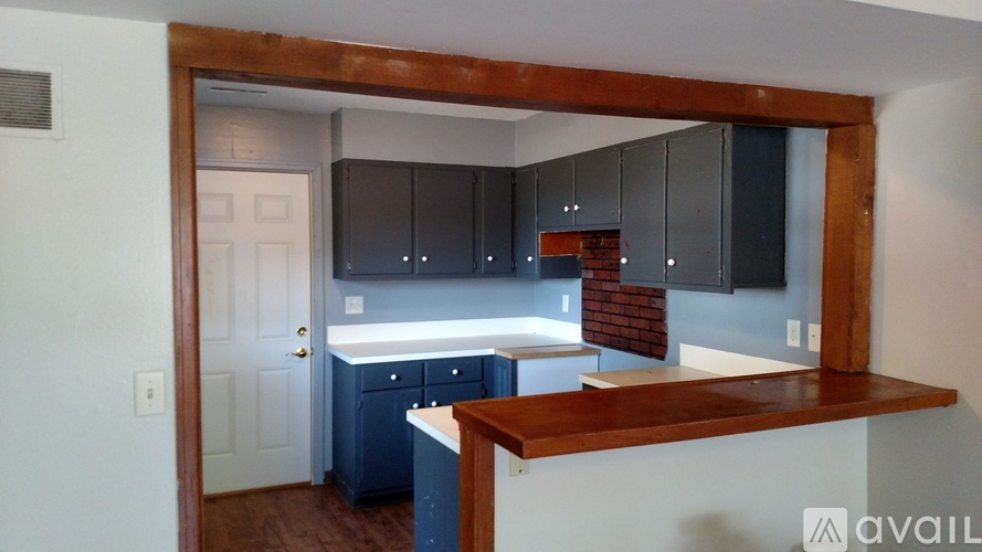 A kitchen with a white door and a brick wall.
