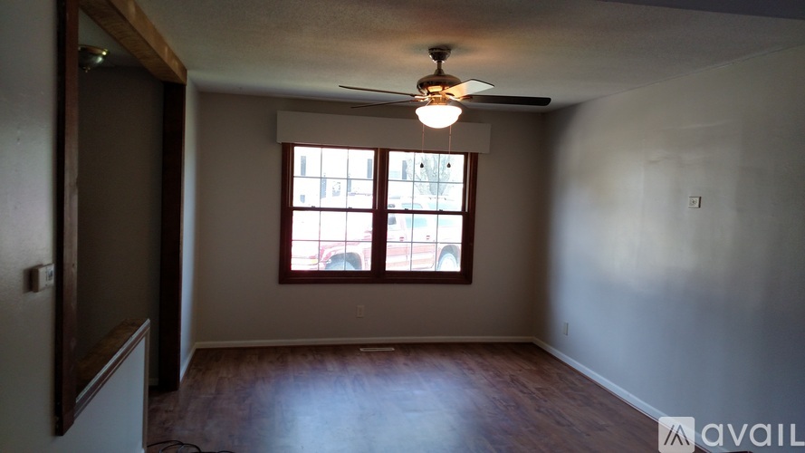 A room with a ceiling fan and a window.
