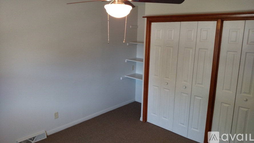 A room with a ceiling fan and a light hanging from it.