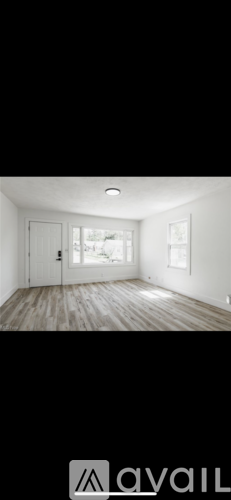 A room with wooden flooring and a large window.