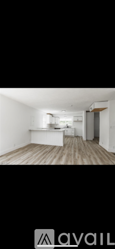 A room with wooden flooring and white walls.