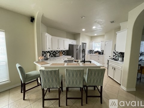 A kitchen with a table and chairs in the middle.