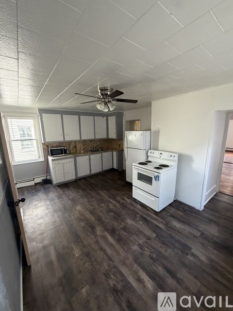 A kitchen with a white fridge, a stove, and a microwave.