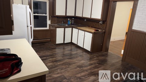 A kitchen with brown cabinets and a white fridge.