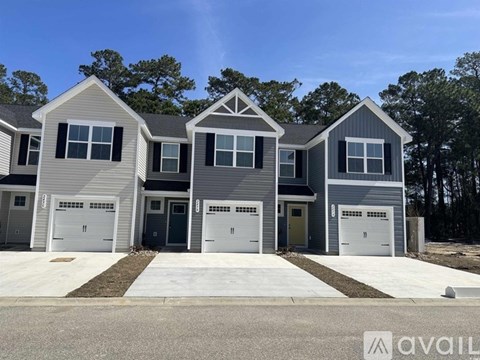A row of houses with garages are available for purchase.