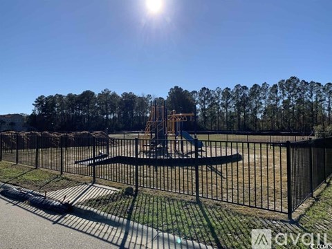 A playground with a swing set and a fence in the foreground.