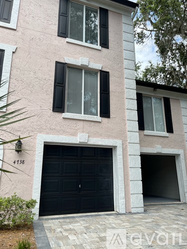 A two-story house with a black garage door and a white trim.