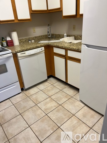A kitchen with white appliances and brown cabinets.