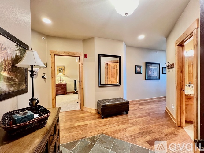 A living room with a wooden floor and a painting on the wall.