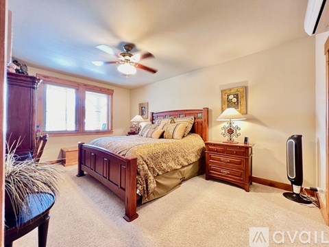 A bedroom with a bed, nightstand, and a ceiling fan.
