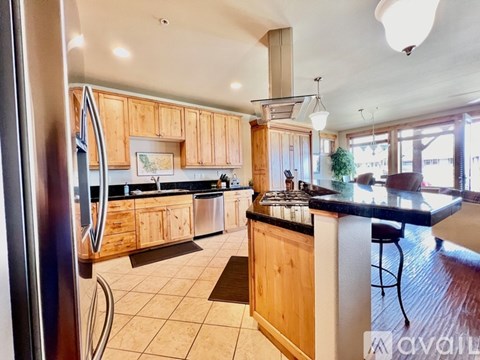 A kitchen with wooden cabinets and a black countertop.