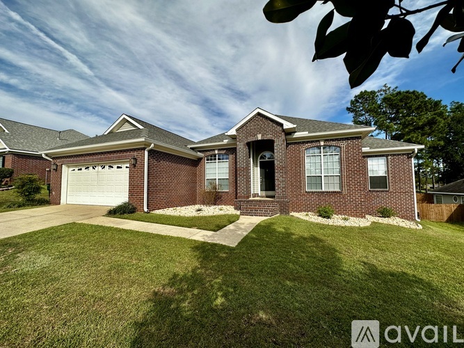 A house with a brick facade and a white garage door is for sale.