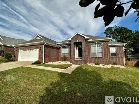 A house with a brick facade and a white garage door is for sale.
