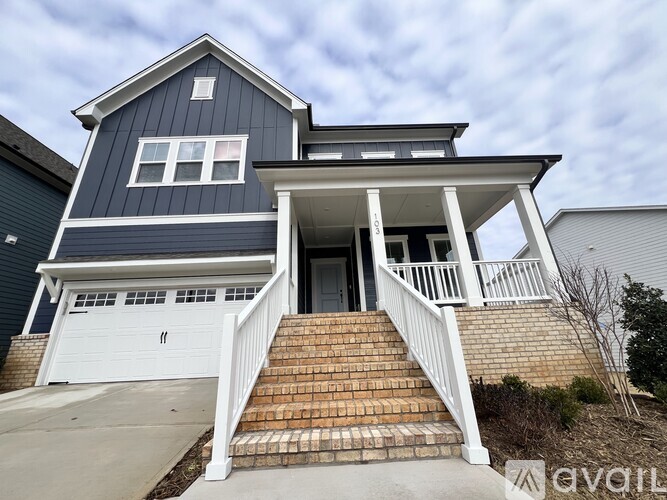 A two-story house with a garage and a covered porch.