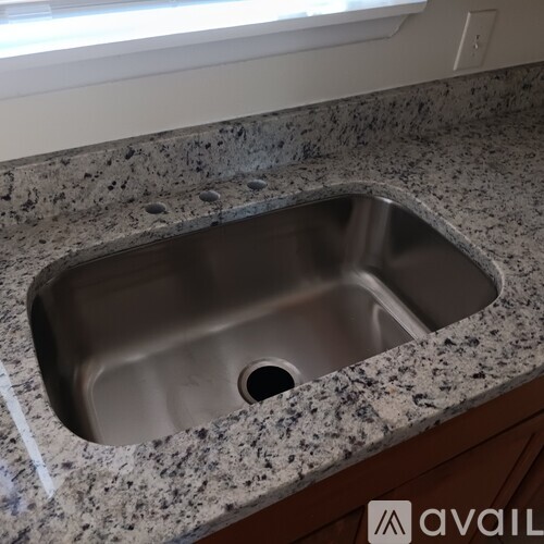 A granite countertop with a sink in the middle.