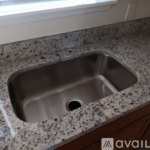A granite countertop with a sink in the middle.