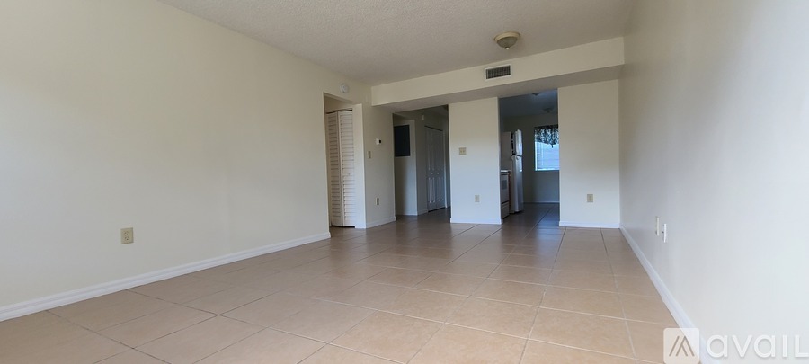 A spacious room with tiled flooring and white walls.